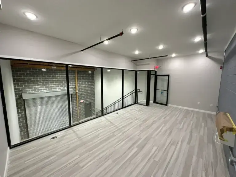 Office view of the commercial space at 3001 Ormes Street in Philadelphia showing new wood tile floors, large glass windows and recessed lighting