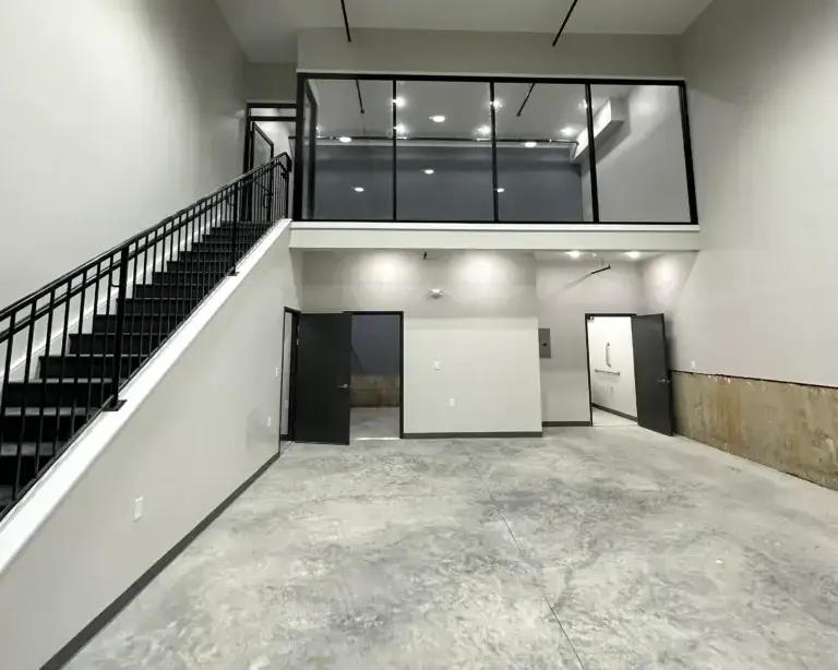 Inside view of the commercial property at 3001 ormes street with an upstairs office, downstairs open area bathroom and storage closet. All in a modern black and white color scheme