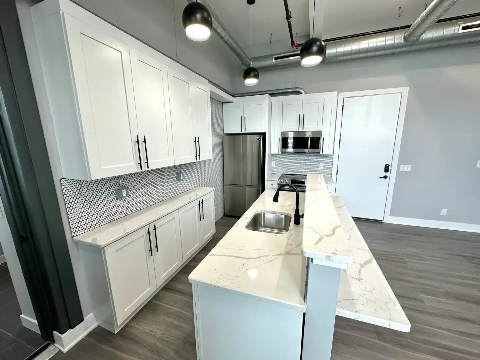 3701 Frankford Ave Unit 202 of the Frankford Loft apartment kitchen featuring marbled quartz counters and tiled backsplash